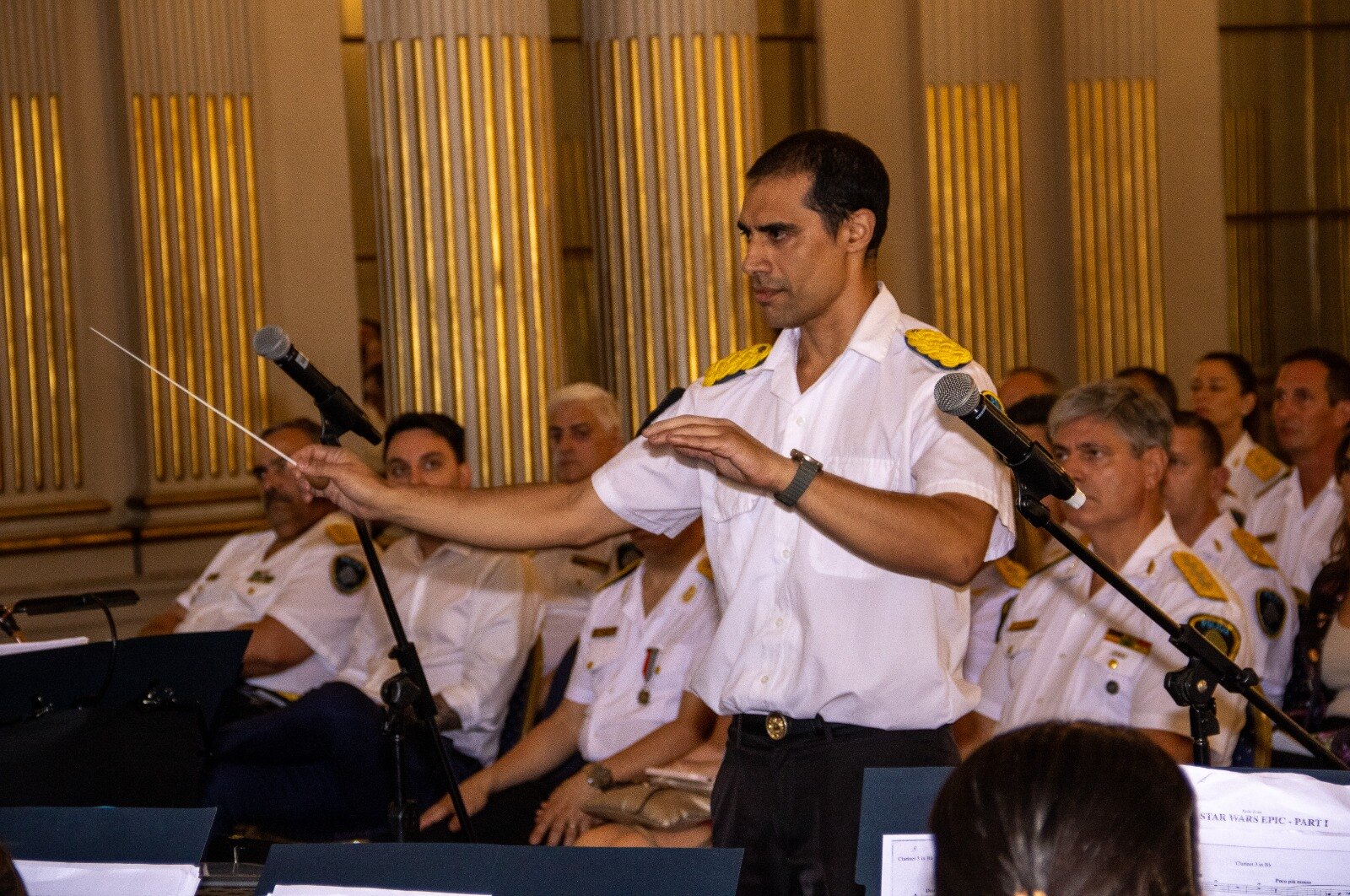 Dirigiendo con la batuta señalando hacia la banda