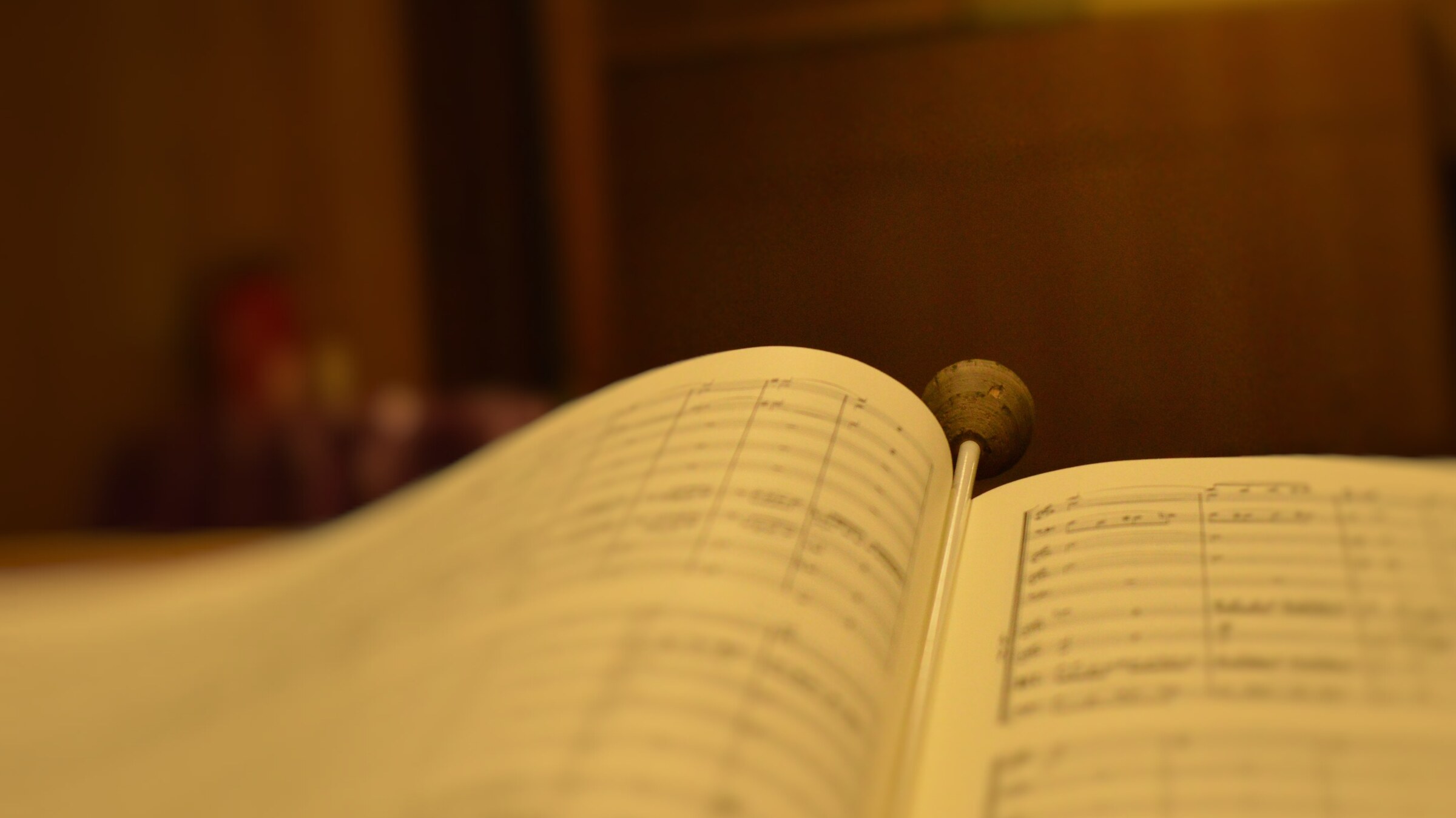 Partitura abierta con la batuta apoyada